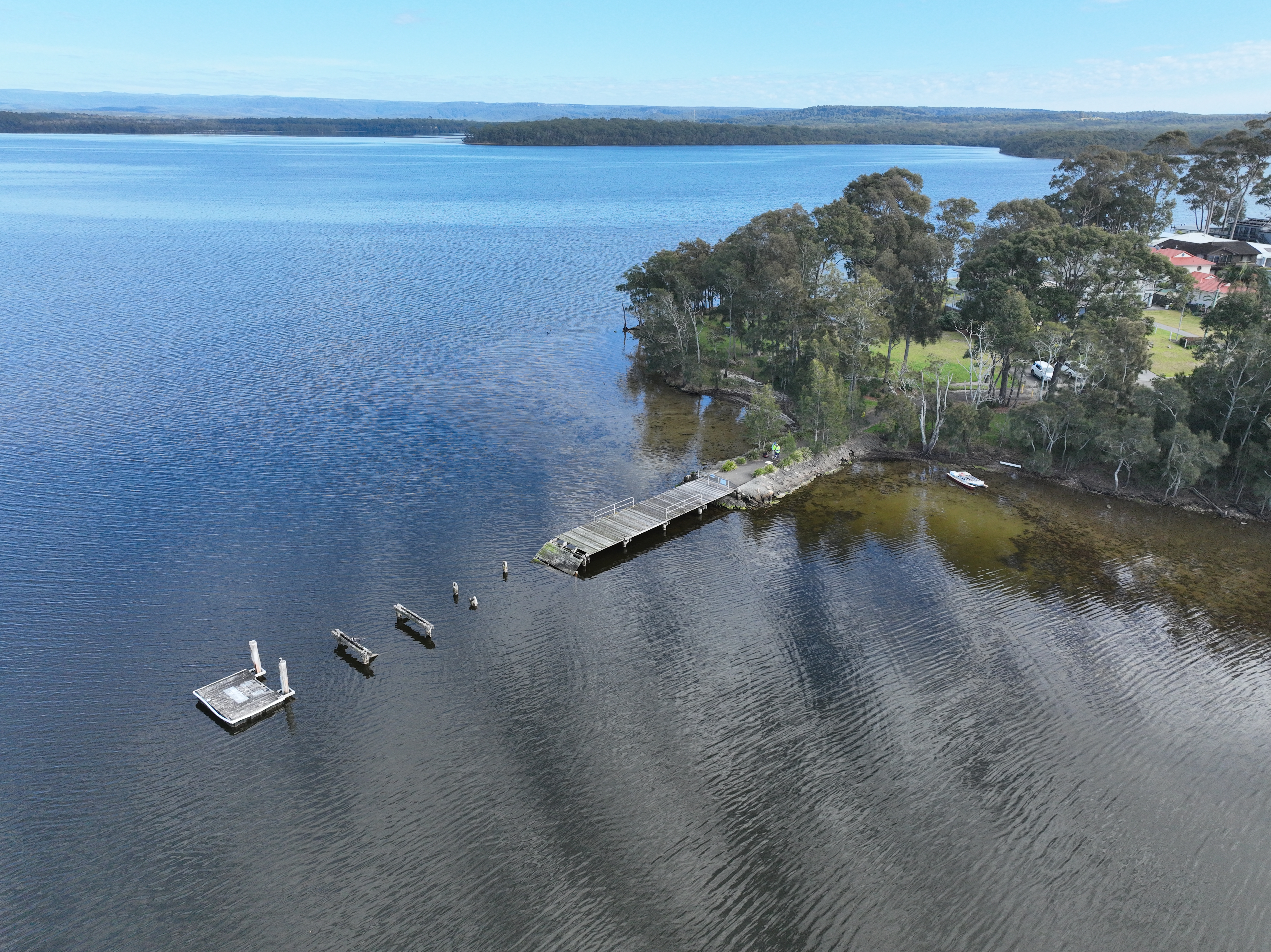 Overhead drone view of damaged jetty and water